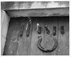 1965.5.1.460 Amulets (horse-shoe and rodent feet) on door of house in Lake District, photographed by Ernest G. Rathenau c. 1950