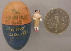 1944.7.61 'World's smallest doll' with its egg, set beside an English 5p coin for scale.